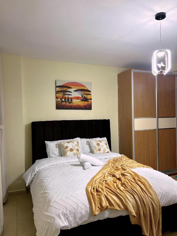 a bedroom with a large bed with white sheets at Alyahomes in Nairobi