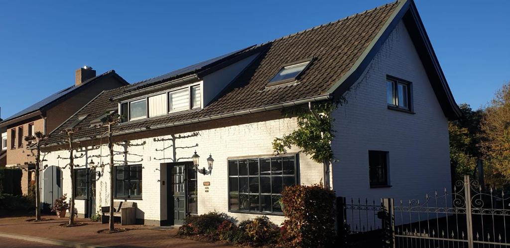 a white and black house with a black roof at Bed and Breakfast Bergs Huuske in Sint Odiliënberg