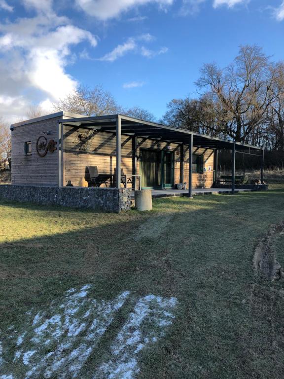 a building with a car garage on a field at Budha house in Lošonec