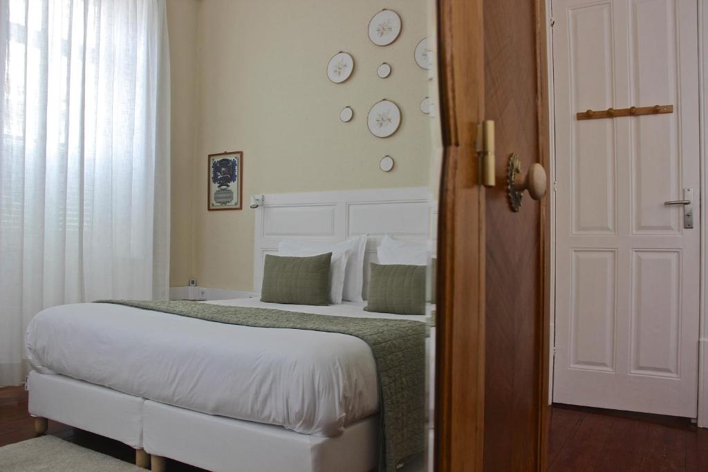 a bedroom with a bed and clocks on the wall at Casa Côrte Real in Porto
