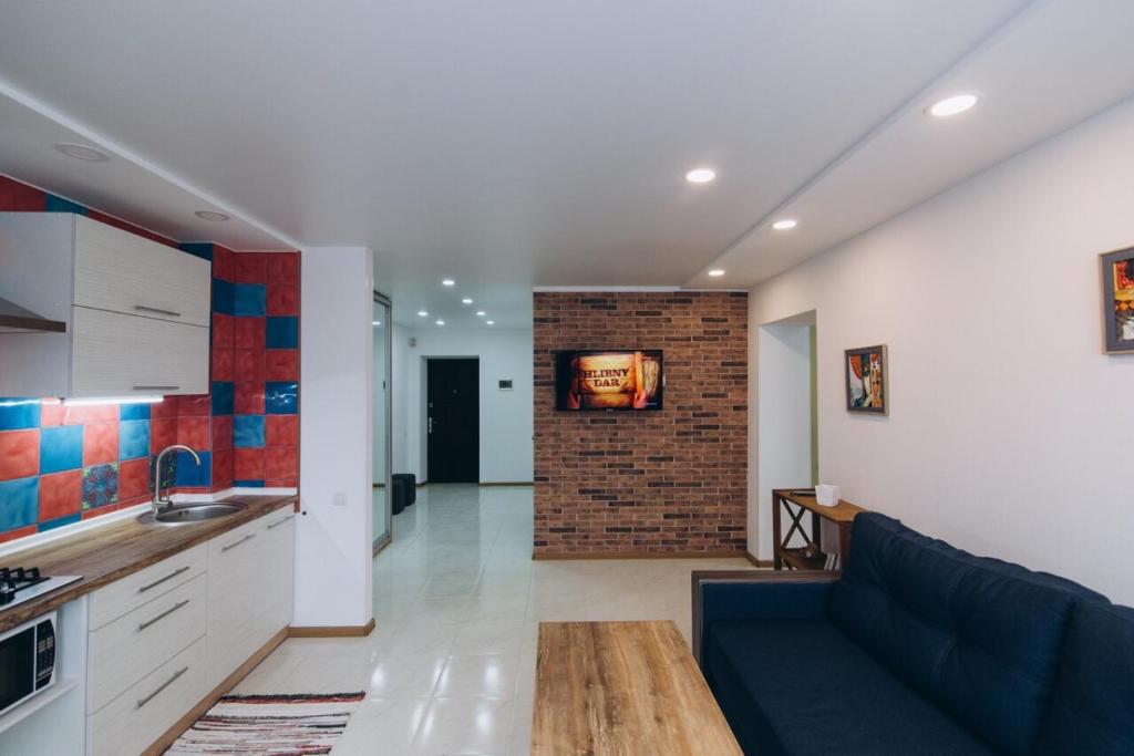 a kitchen and a living room with a couch and a table at Apart Lawina in Sumy