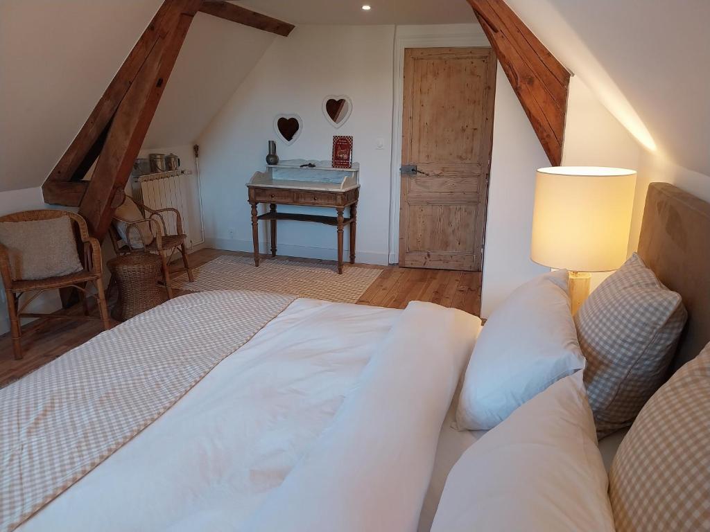 a bedroom with a bed and a table with a desk at La chambre du Villard in Saint-Béron