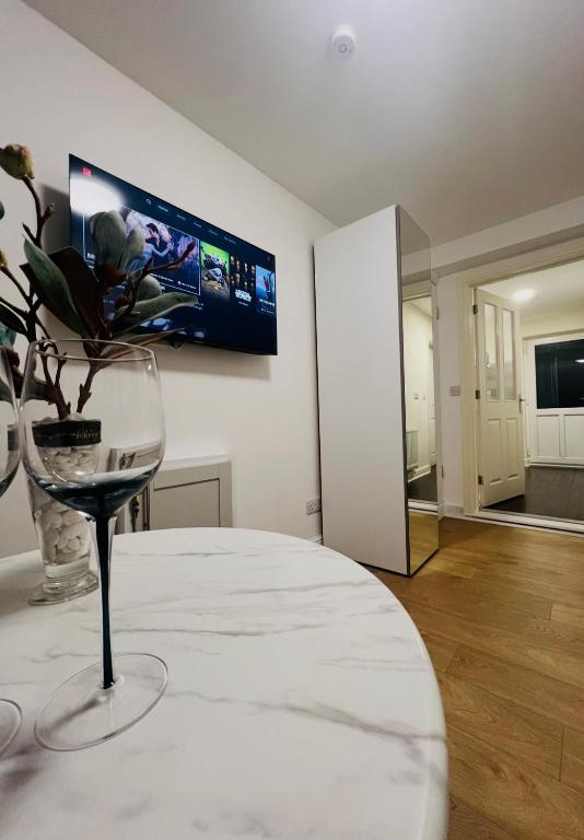 a room with a wine glass and a tv on the wall at Lakes Guest Room Annexe in Penrith