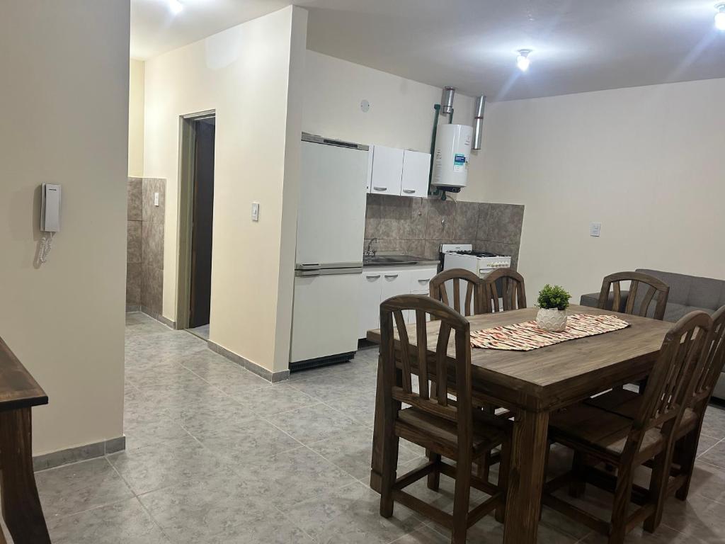 a kitchen with a wooden table and chairs in a room at Cima Departamentos in Rivadavia