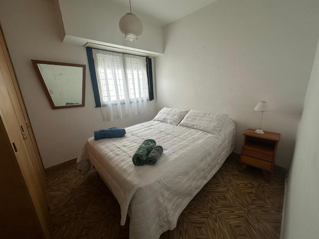 a bedroom with a bed with two shoes on it at La casa de Chola in Playa Unión