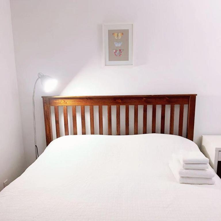 a bedroom with a white bed with a wooden headboard at Dunbar Home in Vancouver