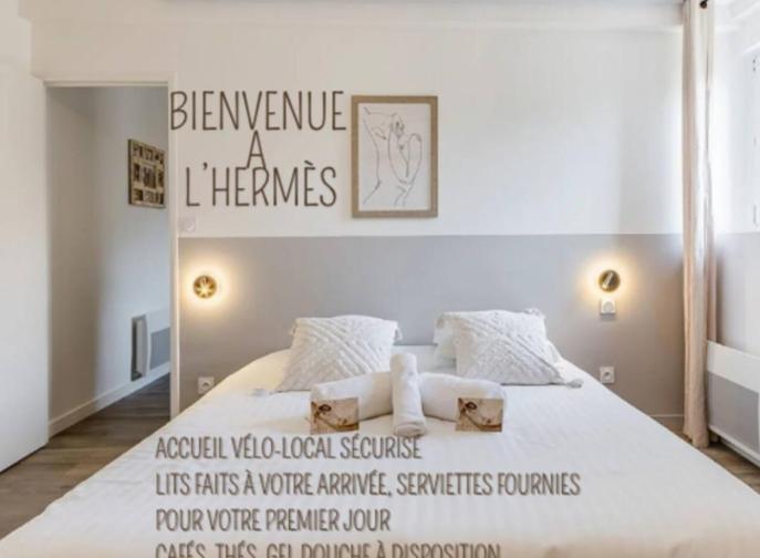 a bedroom with a large bed with a sign on it at L'hermès, raffiné et élégant in Segré