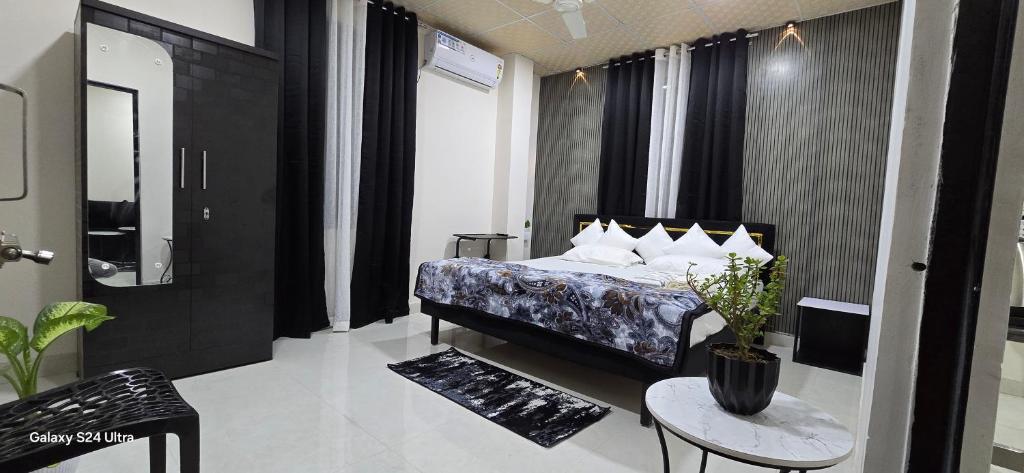 a bedroom with a bed and a table in a room at Lavish Abode black & white in Guwahati