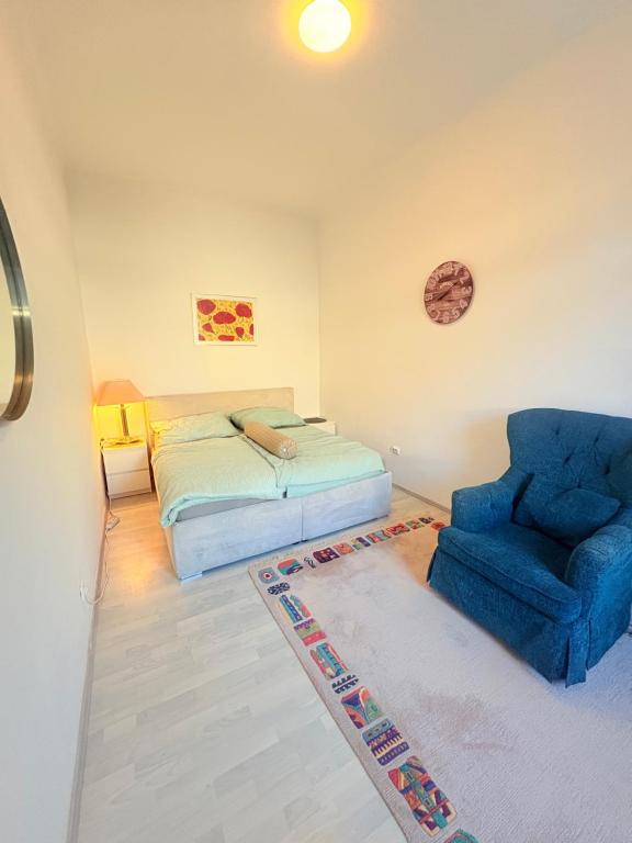 a bedroom with a bed and a blue chair at Beenie 20 in Linz