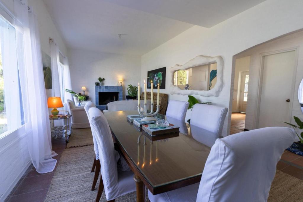 a dining room with a table and white chairs at Casa Blue3 in Punta del Este