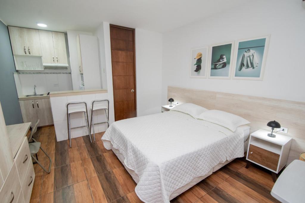 ein Schlafzimmer mit einem weißen Bett und eine Küche in der Unterkunft Studio rent in Piura
