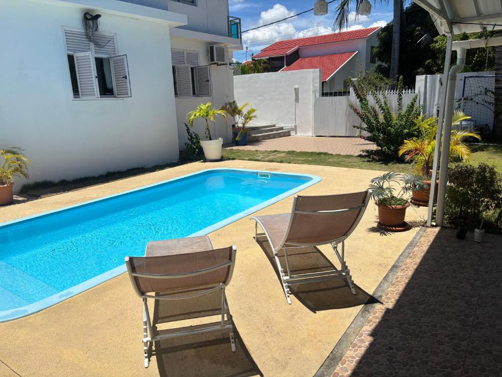 two chairs and a swimming pool in a yard at Villa 3D Grand baie Pereybere in Pereybere