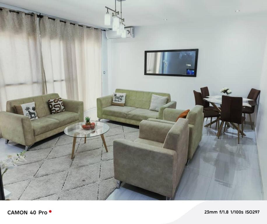a living room with two couches and a table at Serenity in Dakan