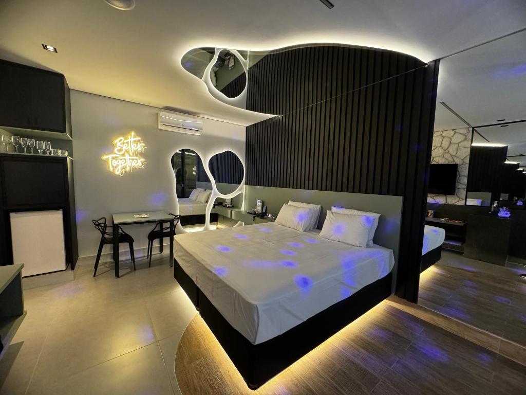 a bedroom with a bed and a table in it at Motel Sedución (Adults only) in Cascavel