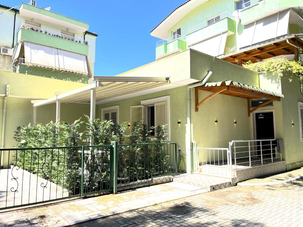 a house with a green fence in front of it at Green Residence by the beach in Golem