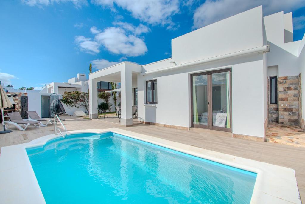 a villa with a swimming pool and a house at Casa Maurizio - Heated Pool, Hot Tub & Hammam in Playa Blanca