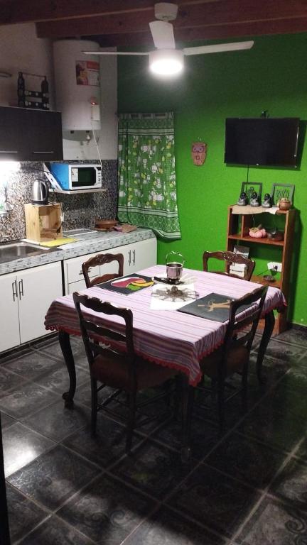 a kitchen with a table with chairs and a green wall at tranquilidad absoluta in Villa Unión