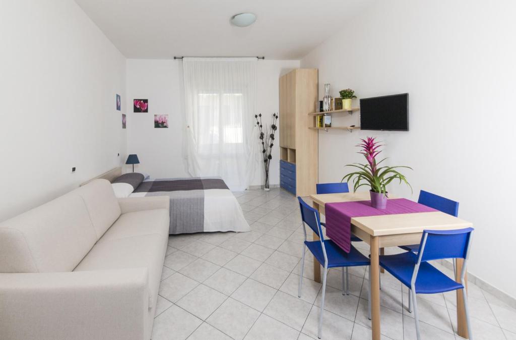 a living room with a couch and a table and a bed at Residence Verbena in Rimini