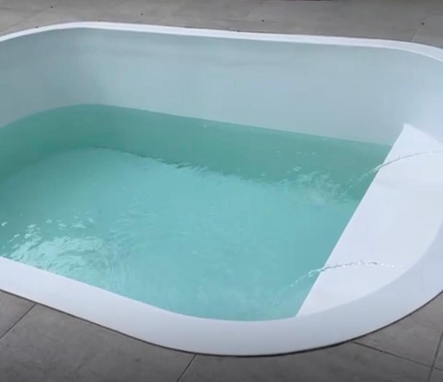 a bath tub with a blue light on it at Casa com piscina in Araruama