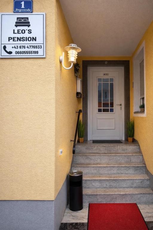 a front door of a building with a red rug at Leo's Pension in Bad Schallerbach