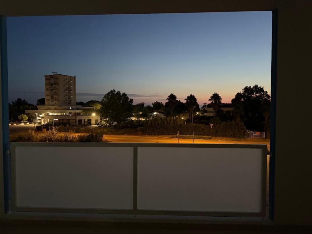 a window with a view of a city at night at Brezza Marina - Vacation Condo in Marina di Vasto