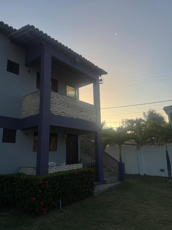 a house with the sunset in the background at Barra Adventure Pousada in Mataraca