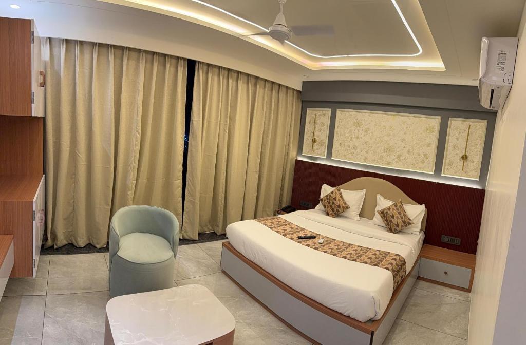 a hotel room with a bed and a chair at Hotel Vallabh Sky in Goya Gate