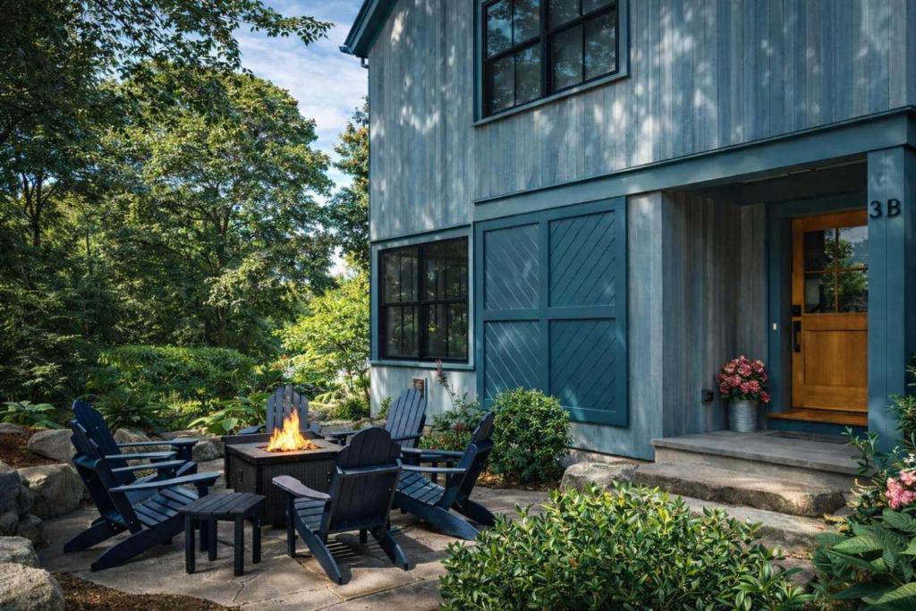 a patio with chairs and a fire pit in front of a house at Stay at Old Garden Beach in Rockport