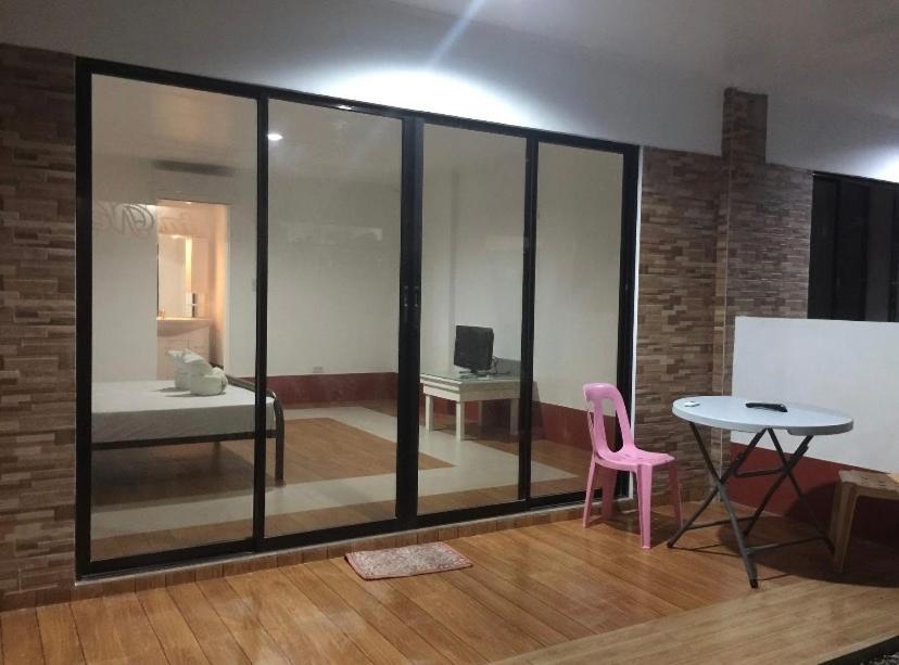a room with a pink chair and a table at Alona Chrisah Apartelle in Panglao Island