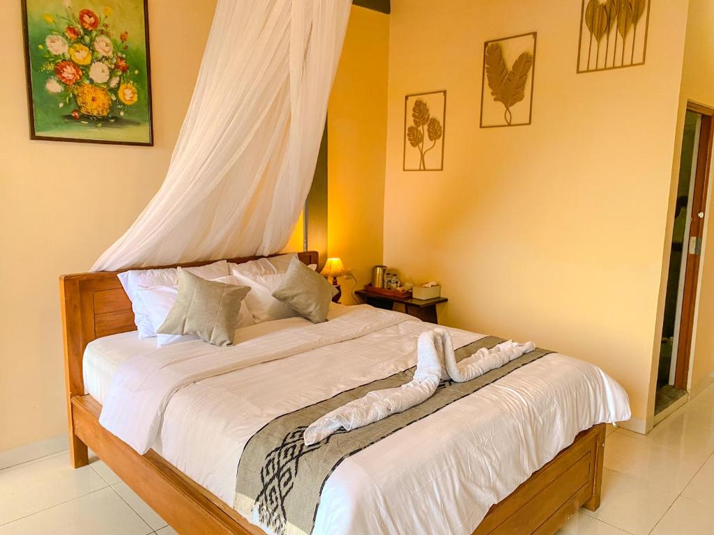 a bedroom with a bed with a canopy at Geriya Sena in Munduk