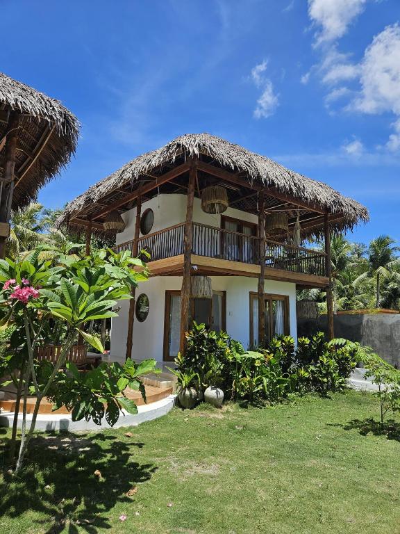 a large house with a thatched roof at Pangaro House in Katiet
