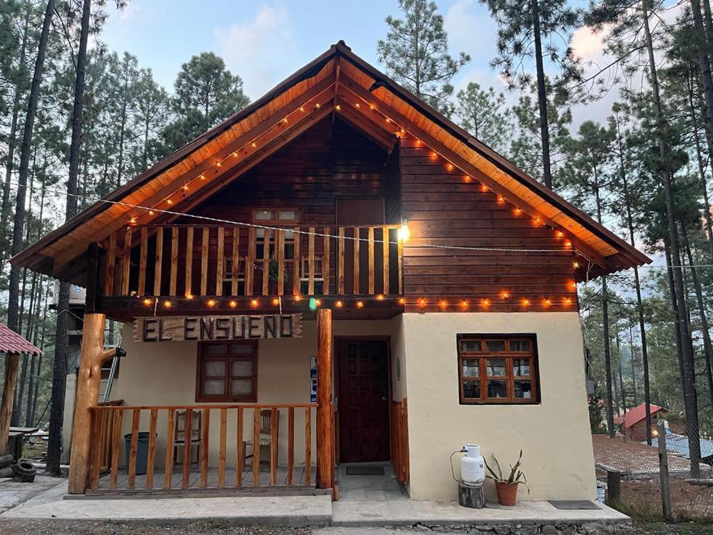 a small log cabin with a porch and a deck at Cabañas El Ensueño in La Ciudad