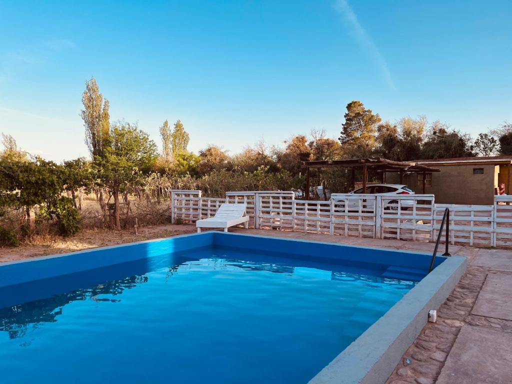a swimming pool in a yard with a white fence at HOTEL FINCA AMANCAY in Villa Unión