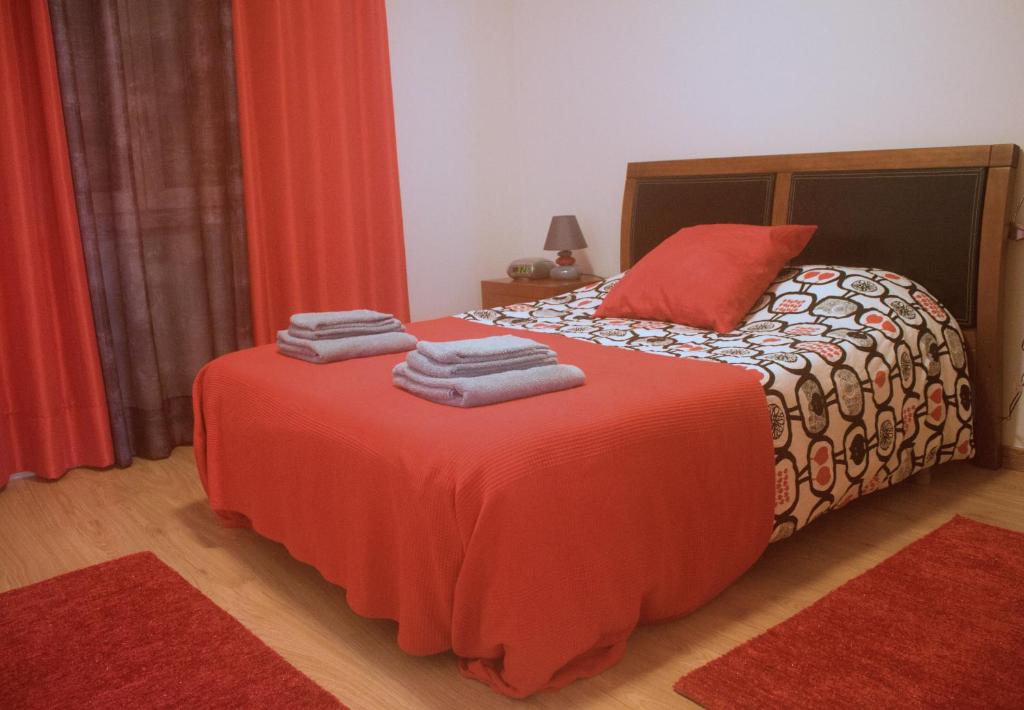 a bedroom with a bed with towels on it at Saudade Peniche Apartment in Peniche