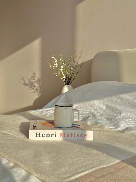 a book and a cup on a bed with aeth mattress at Azur Stay in Kwangan-dong