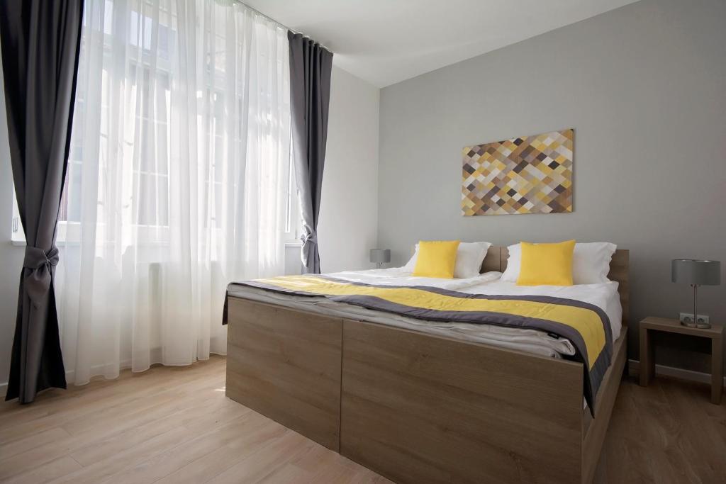 サラエボにあるエンジョイ アパートメンツのベッドルーム1室(大型ベッド1台、黄色い枕付)