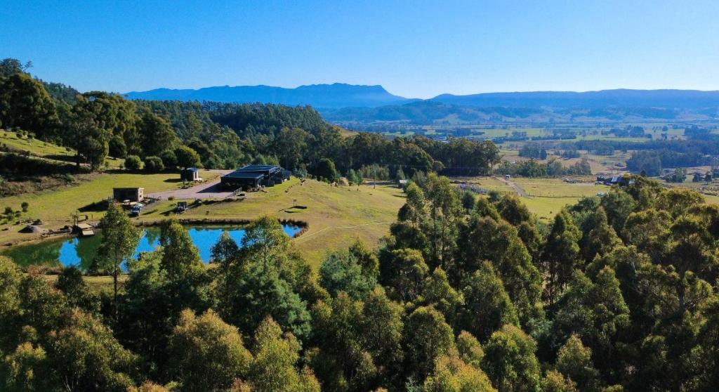 an aerial view of a farm with a pond at The Top Place Retreat in Caveside