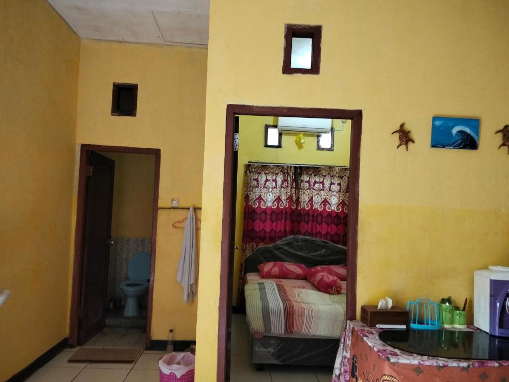 a room with a bedroom with a bed and a toilet at Papua Risen Beach Front Bungallow in Insyurifuri