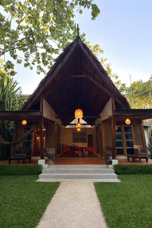 a house with a large roof with a patio at Patrick's on the Beach Resort in General Luna