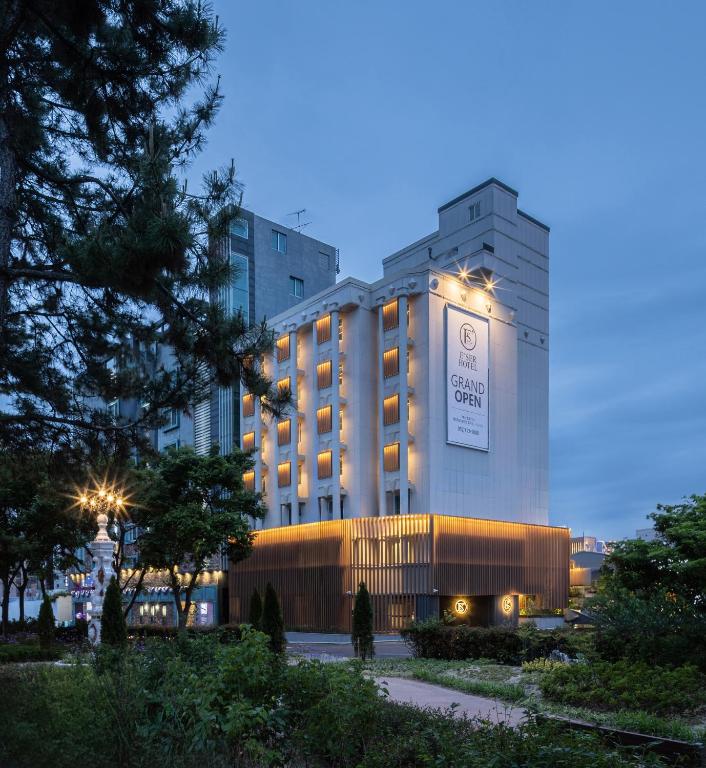 a hotel with a building with a clock on it at Ulsan Mugeo E'ser Hotel in Ulsan
