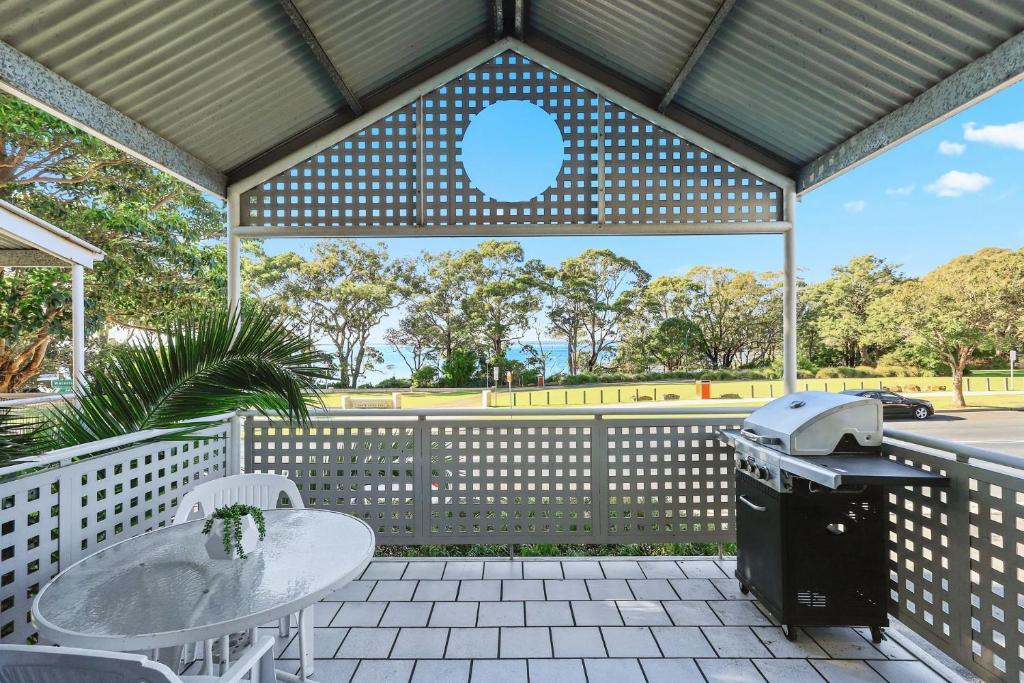a patio with a grill and a table and chairs at ParkView on Owen in Huskisson
