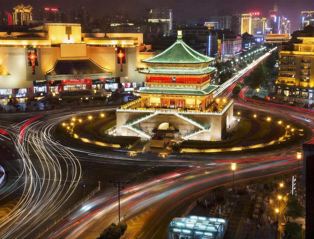 a city with a building and traffic at night at QiYu Hotel - Xian Bell Tower in Xi'an