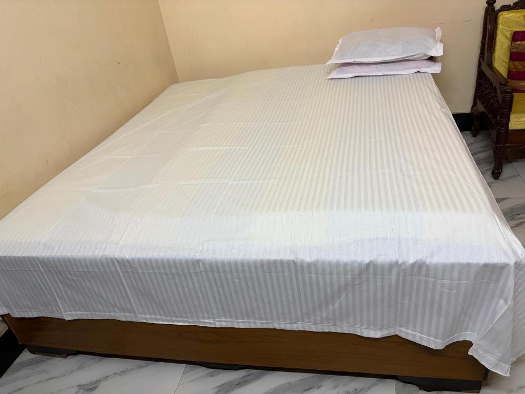 a bed in a room with a white mattress at Cozy braket in kolkata