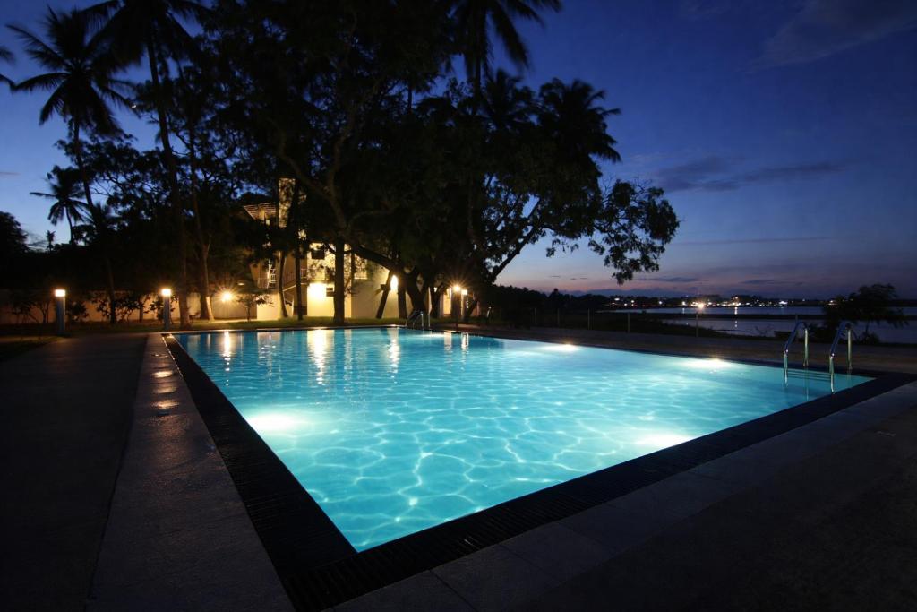 a swimming pool lit up at night at Jade Green Hotel Hambantota in Hambantota