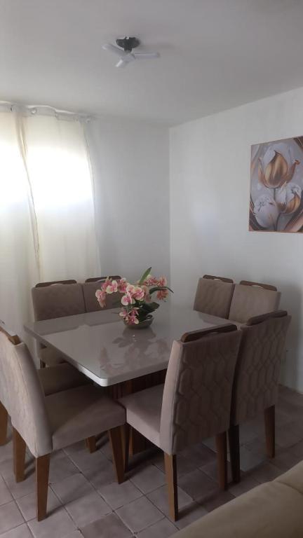 a dining room table and chairs with flowers on it at Casa Samambaia in Piranhas