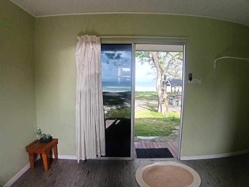 a room with a door with a view of the ocean at Kudat Beach House 4 in Kudat