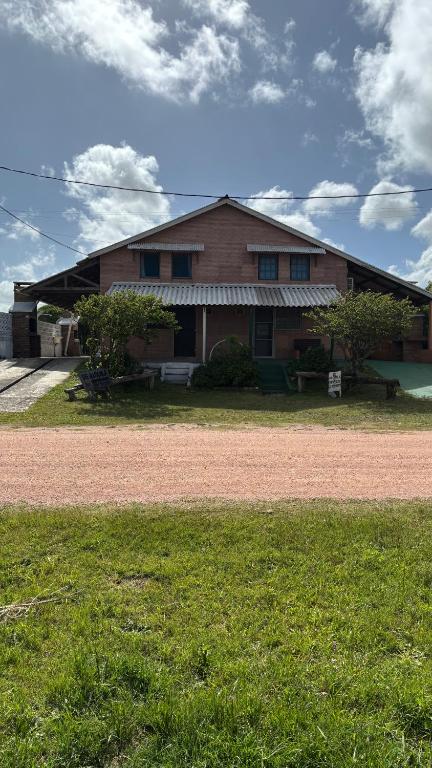 a house with a grass field in front of it at Los Rochas, Barra de Chuy in Barra del Chuy