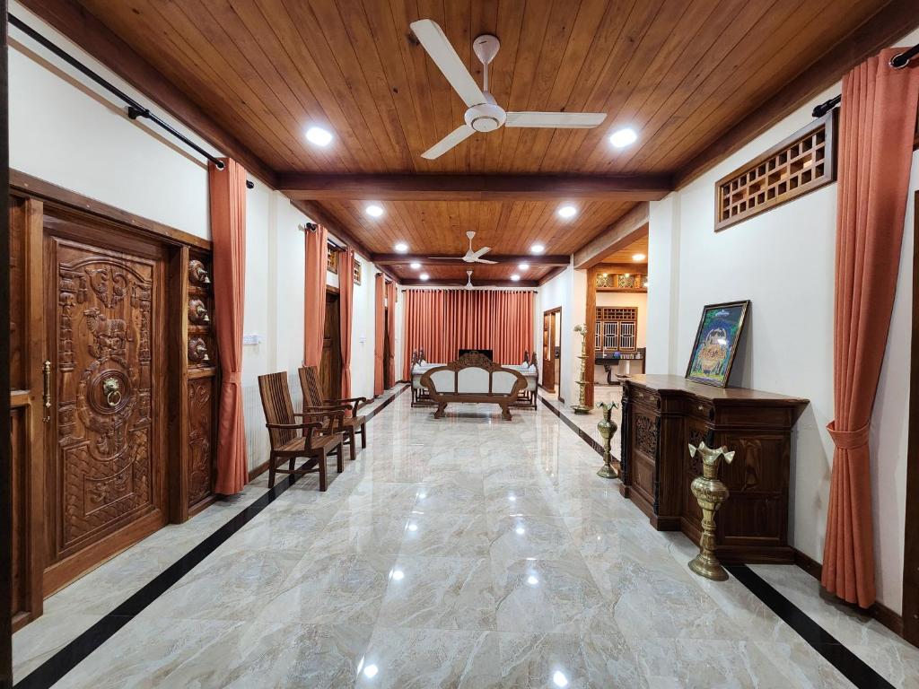 a hallway with a ceiling fan and a living room at Mahizh Manai in Jaffna