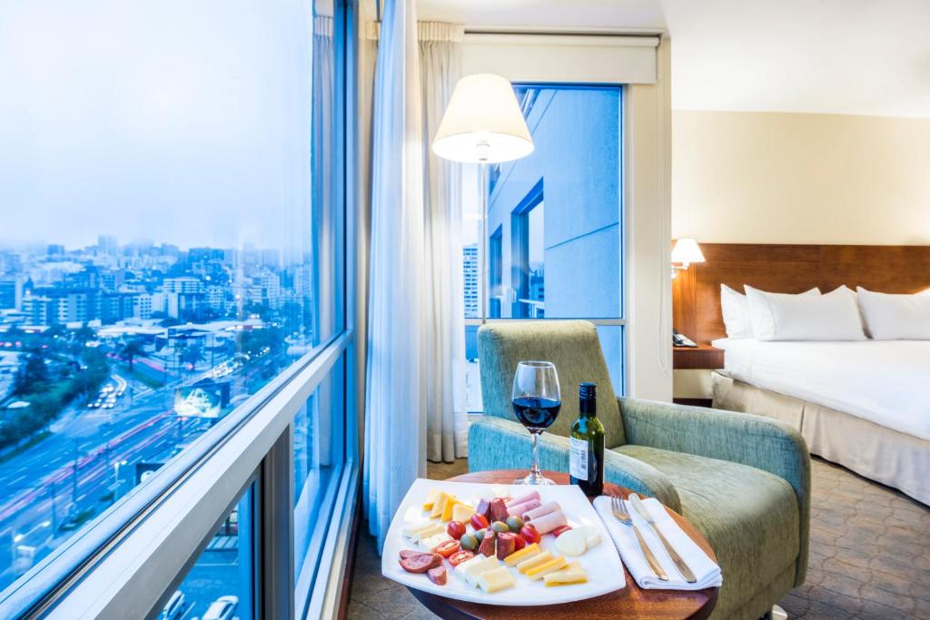 a room with a bed and a table with a glass of wine at Holiday Inn Express Quito by IHG in Quito