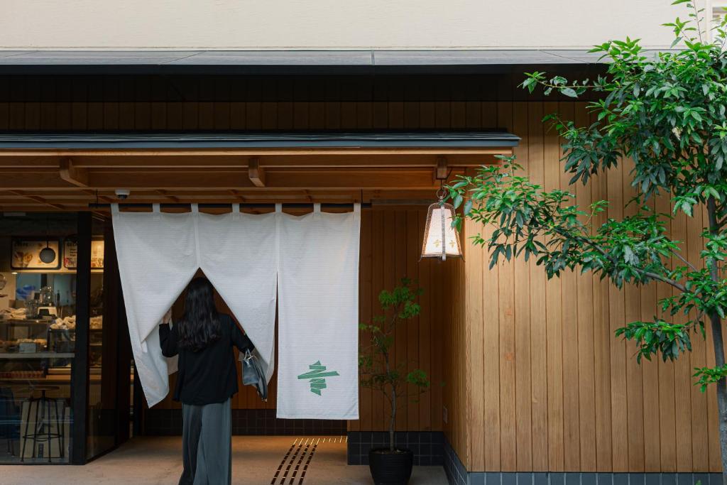 a person standing in front of a building with a window at soyo-ne kyoto sanjo in Kyoto